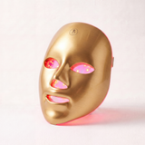 LED gezichtsmasker op marmeren tafel met skincare producten